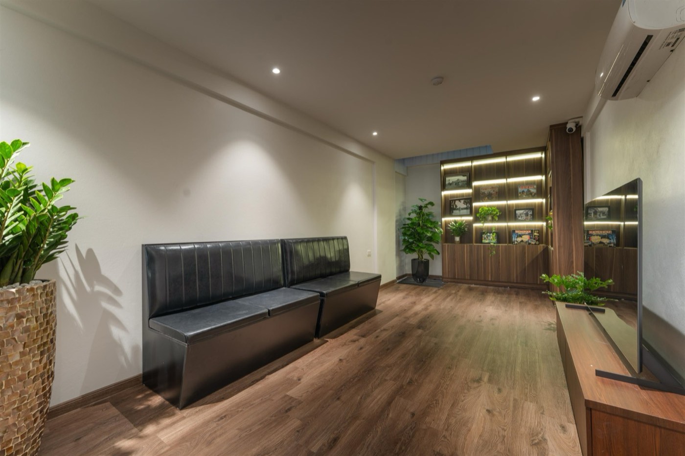 Lounge with long black sofas and a TV