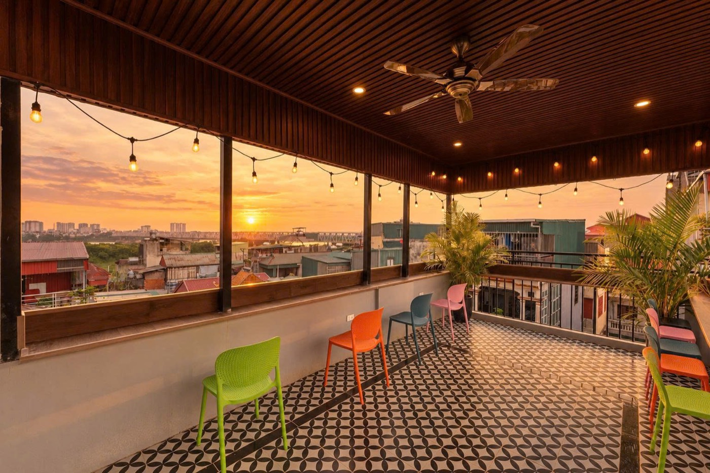 The covered terrace at sunset, string lights and colourful chairs